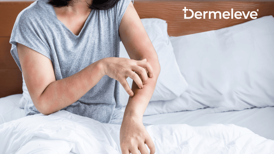 A woman on a bed, extending her arm outward, scratching her skin